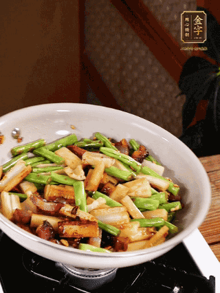 油热下蒜末、干辣椒、酱肉煸炒出香味，依次下藕条、豆角翻炒均匀